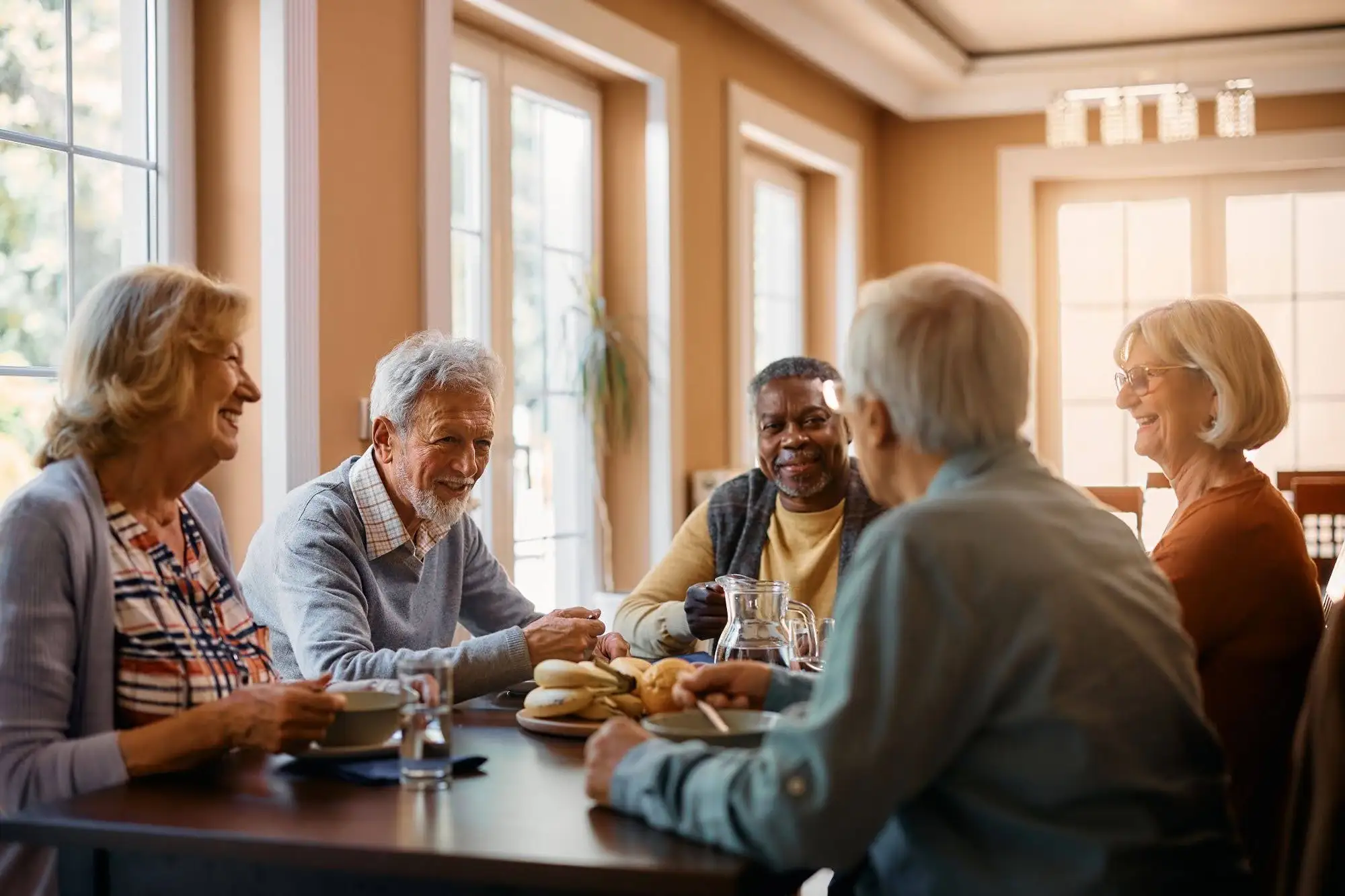 Stay Active and Independent: Healthy Aging Tips for Seniors 2 A group of 5 seniors enjoying social connection and a healthy diet, as part of the healthy aging tips for seniors.