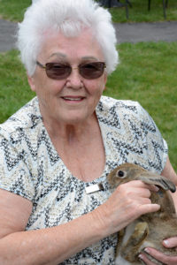 Resident Joyce Pollara enjoys a quick cuddle with one of the bunnies that Animal Affair brought to Village at Proprietors Green for the Annual Family Day gathering.