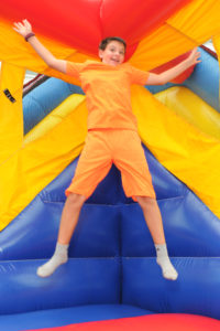 Max Toomey, 12, of Wellfleet, who was visiting his grandmother, resident Margaret Vernaglia, enjoys a big bounce while inside the Inflatable Bounce House during the community’s Family Day.