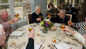 Good times are better when you can share them with your friends. From (l to r) Stan and Mary Roller raise their glasses as their friends toast their good fortune and enduring union. Clockwise, other residents include, Mary Grundman, Charlotte and Ralph Buliung (not seen), and to the left of Stan Roller, Frank Grundman.